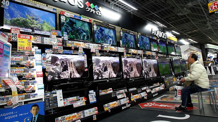 Mediales Überangebot: Dieser japanische Herr sitzt nicht in seinem Wohnzimmer, sondern wartet in einem Elektronikladen vielleicht nur auf seine Frau..