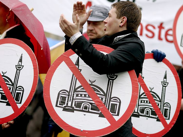 Während der Grundsteinlegung protestieren Anhänger der rechtsradikalen Gruppierung Pro Köln.