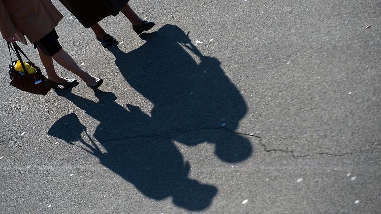 Zwei ältere Damen spazieren am Rheinufer entlang.