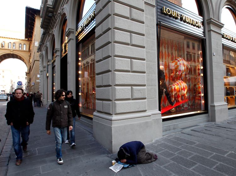 Ein Obdachlosen auf einer Einkaufsstraße in Florenz. Tragen die Europa-Politiker das Sozialstaatsmodell zu Grabe?