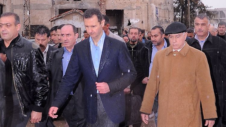 Assad lässt sich durch die zerstörten Viertel von Baba Amr, unweit von Homs, führen.