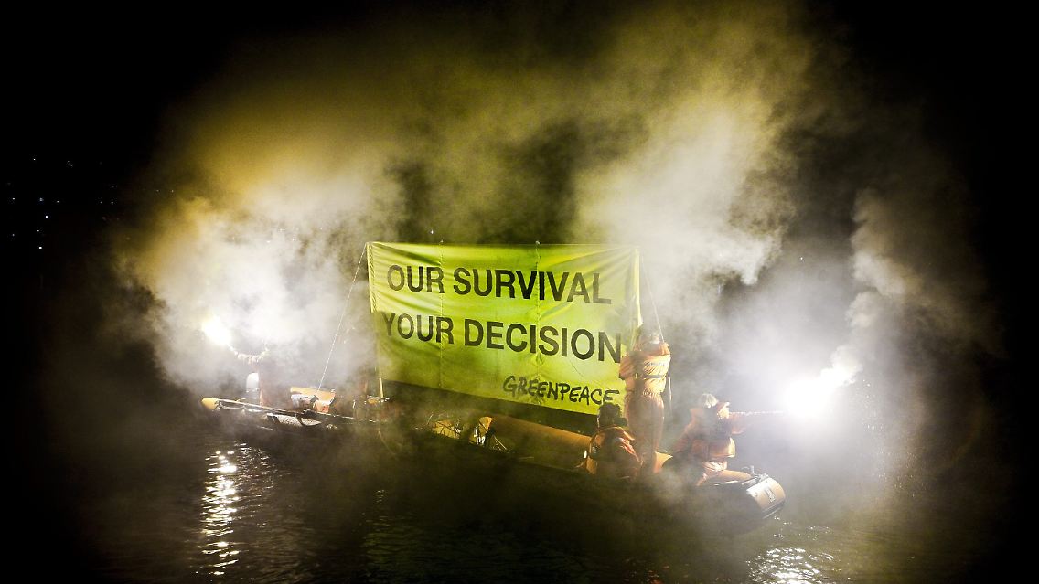 Greenpeace-Aktivisten zeigen in Kopenhagen ein Schild mit der Aufschrift "Our survival - your decision" (Unser Überleben - Eure Entscheidung).