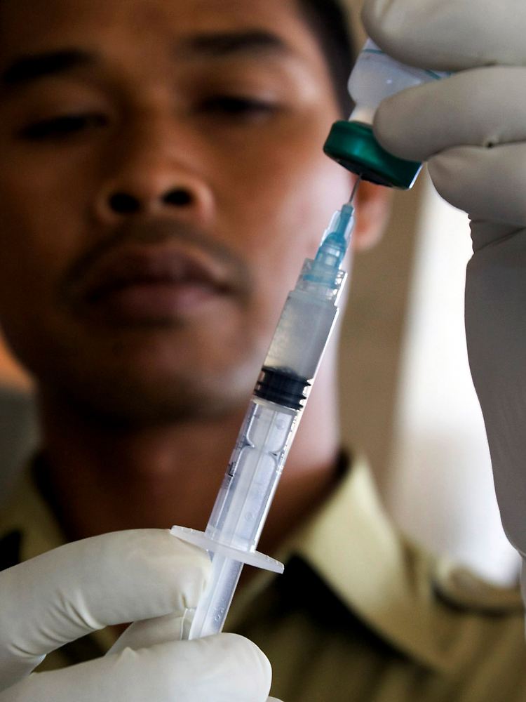 Indonesischer Mediziner mit einer Spritze gegen Tollwut ...