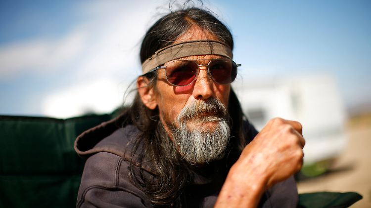 Randy Stevenson sitzt vor einem Wohnwagen in Slab City. Der völlig abgelegene Ort in Kalifornien bietet etlichen arbeitslosen und verarmten US-Amerikanern ein Heim.