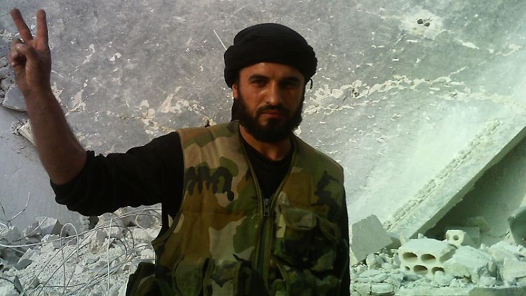 Ein Mitglied der freien Syrischen Armee zeigt das Friedenszeichen - inmitten des zerbombten Ortes Taftanaz.