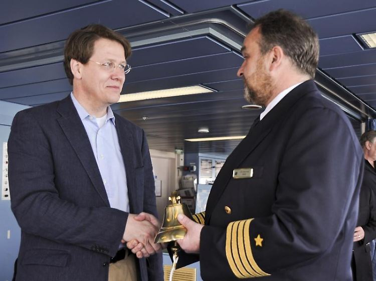 Der Sprecher der Geschäftsführung von Hapag Lloyd Kreuzfahrten, Ahrens (l), überreicht dem Kapitän der "Columbus 2", Gottschalk, am 9. April symbolisch eine Schiffsglocke.