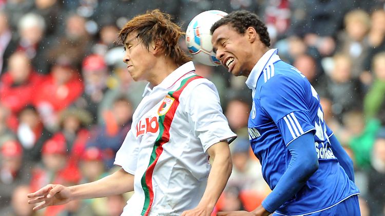 Augsburg Hosogai im Kopfballduell mit Schalkes Matip. Mittendrin: der Ball.