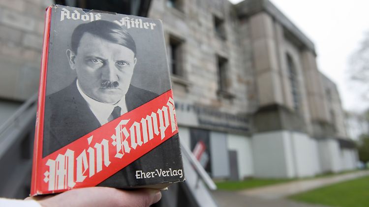 Eine Ausgabe wird vor dem Dokumentationszentrum Reichsparteitagsgelände hochgehalten.