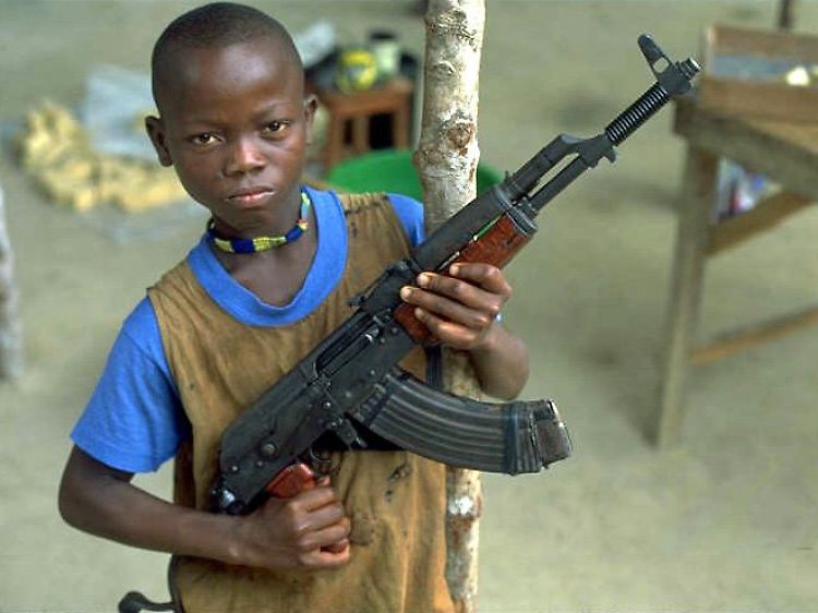 Ein zwöfjähriger Kindersoldat präsentiert in Sierra Leone seine Kalaschnikow - eine von rund 70 Millionen weltweit.