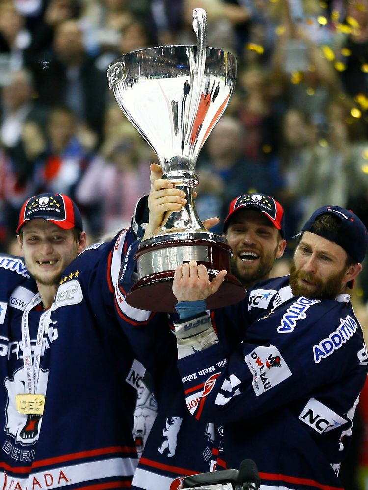 Glückliche Eisbären: Frank Hördler und Richard Regehr helfen Felski beim Tragen des Meisterpokals.