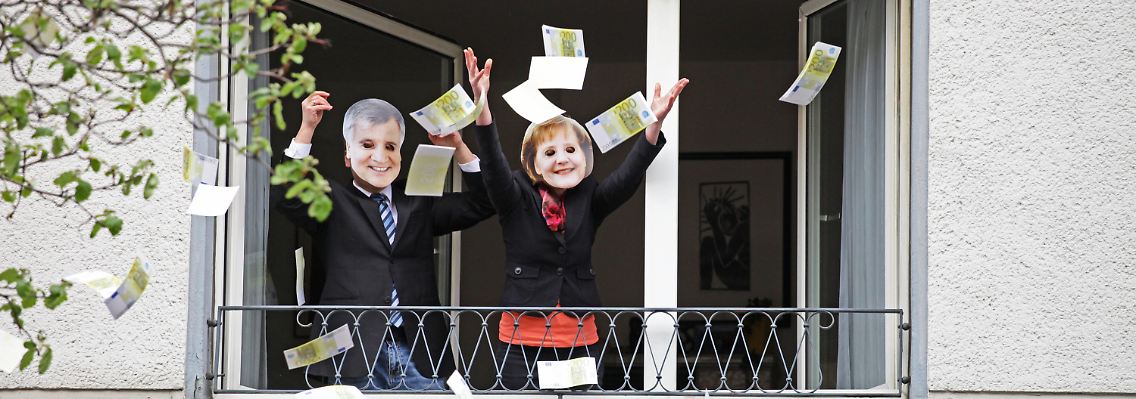 Wahlkampf in NRW: In Düsseldorf werden Grüne mit Seehofer- und Merkel-Masken Geld aus dem Fenster.