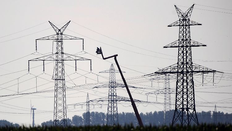 Zwei Monteure arbeiten an einem Strommast.