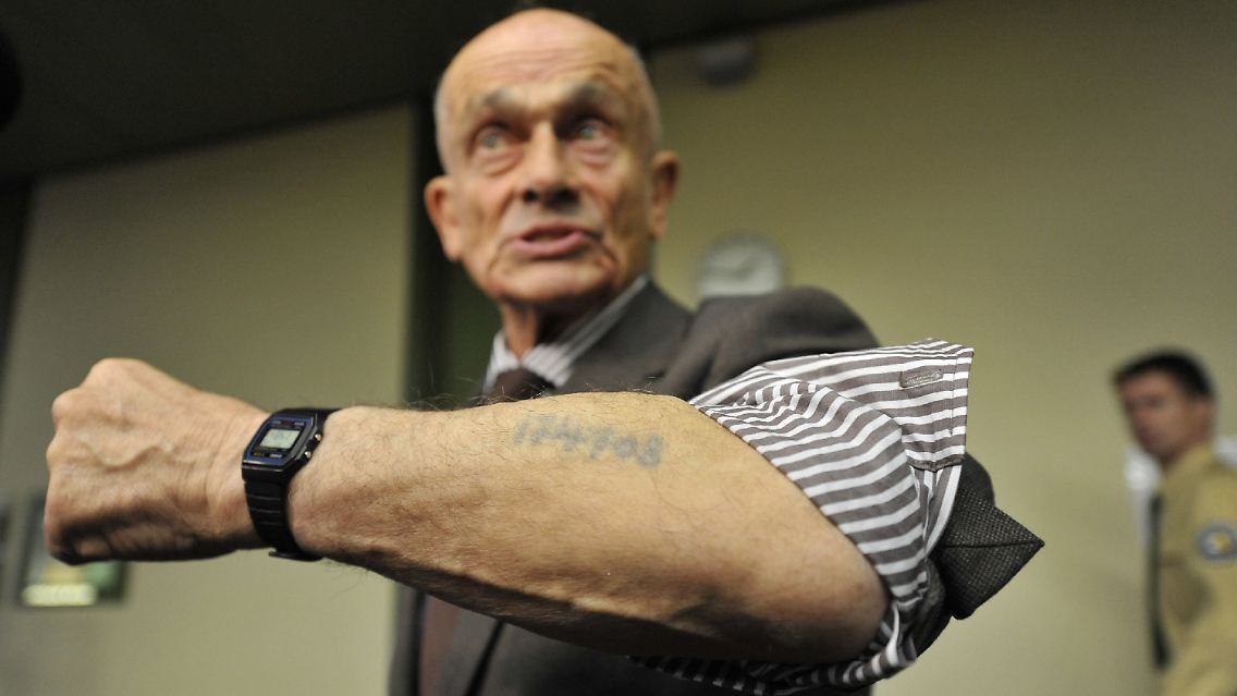 Der KZ-Überlebende und Nebenkläger Robert Cohen zeigt im Landgericht München seine KZ-Tätowierung aus Auschwitz-Birkenau. Cohen verlor Angehörige in Sobibor.