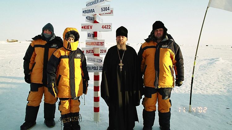 Abenteuertourismus in Russland: Eine Touristengruppe trifft am Nordpol einen russisch-orthodoxen Priester. Viele russische Reiseanbieter haben Flüge zum Nordpol im Programm, wer will, kann auch mit dem Fallschirm abspringen.