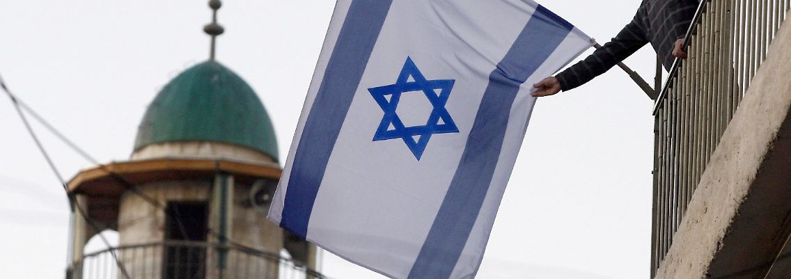 Ein jüdischer Siedler hisst eine Fahne im muslimischen Viertel der Jerusalemer Altstadt in der Nähe des Damaskus-Tores – nur durch die Straße von einer Moschee getrennt.