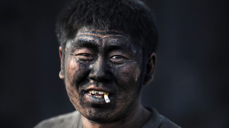 Ein Gleisarbeiter beim Ausladen von Kohle: Zwei Drittel seiner Energie gewinnt China aus Kohle.