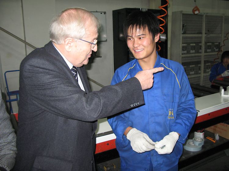 Bundeswirtschaftsminister Rainer Brüderle im angeregten Gespräch mit einem Werktätigen des deutschen mittelständischen Tor- und Türenherstellers Hörmann in Peking.