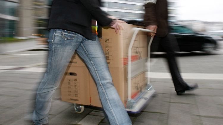 Einsatzkräfte des Landeskriminalamts Baden-Württemberg rollen Kartons mit Unterlagen aus der LBBW.