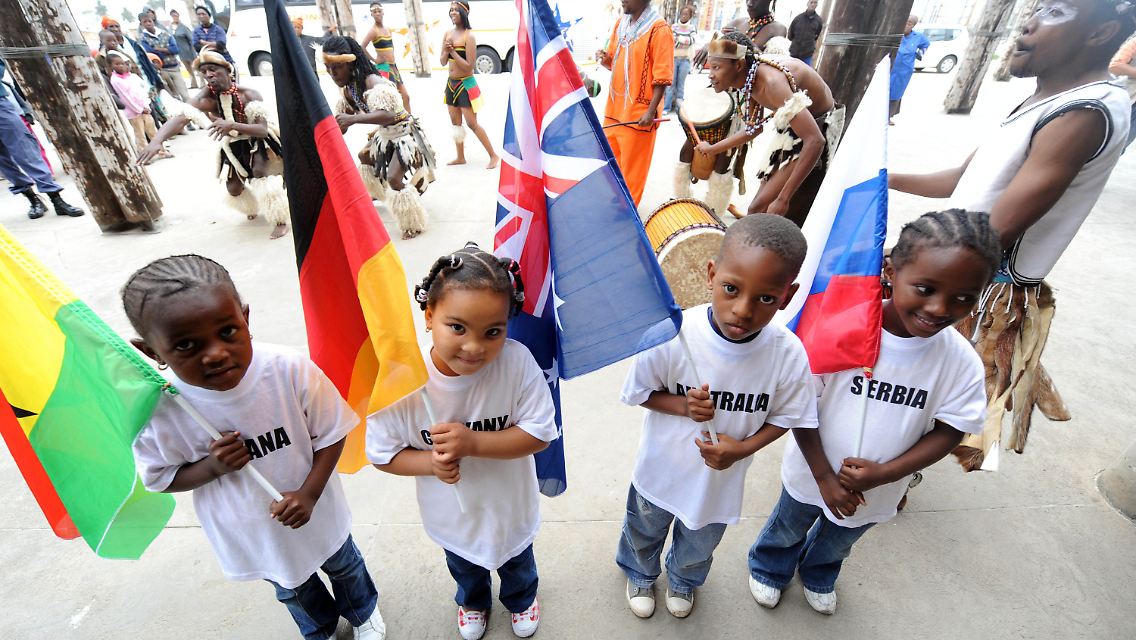 Kinder mit Fahnen der an der Fußball-WM beteiligten Nationen der deutschen Gruppe in Nelson Mandela Bay.