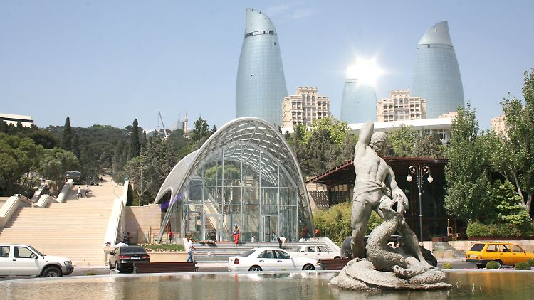 Ein Brunnen in der Innenstadt von Baku, die Flametowers im Hintergrund.