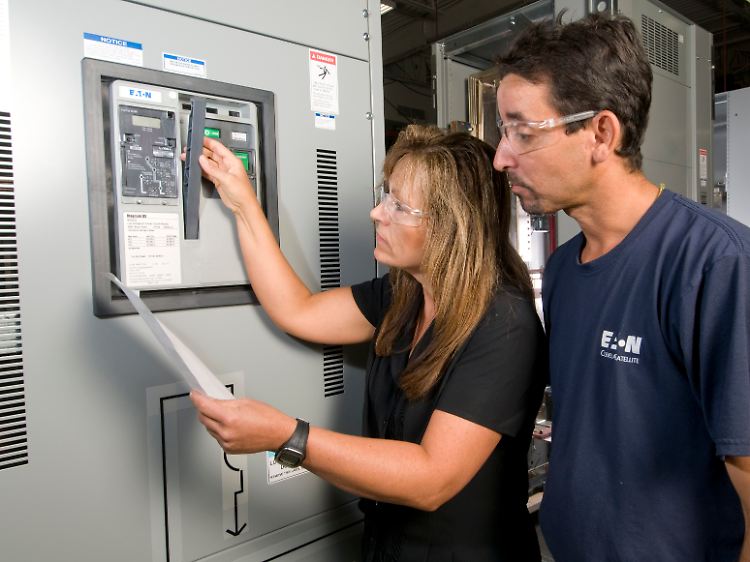 Arbeitsalltag bei Eaton: Zwei Niederspannungstechniker werfen prüfende Blicke auf eine versandfertige Anlage.