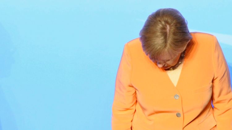 Kanzlerin Merkel beim Nato-Gipfel: Suche nach dem Namensschild fürs Familienfoto.