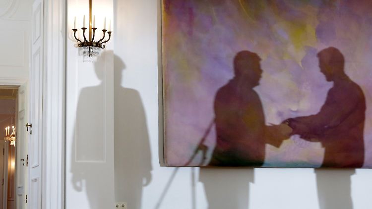 Die Schatten von Bundespräsident Gauck (M.), Bundeskanzlerin Merkel (l.) und Ex-Umweltminister Röttgen bei der Überreichung der Entlassungspapiere im Schloss Bellevue.