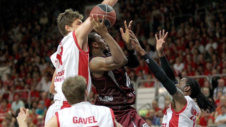 Die Bamberger Spieler Tibor Pleiß (l.), Anton Gavel (unten) und Julius Jenkins (r.) blockieren Anthony Hilliard von den Artland Dragons.