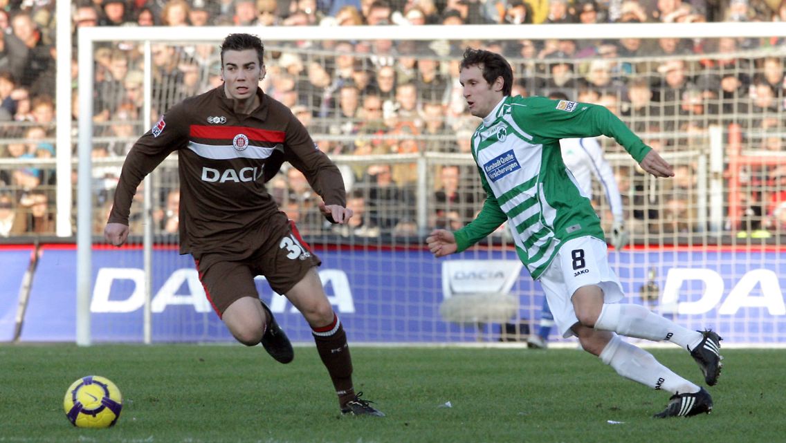 Dennis Daube, links, vom FC St. Pauli und Stephan Fürstner vom SpVgg Greuther Fürth schauen auf den Ball.