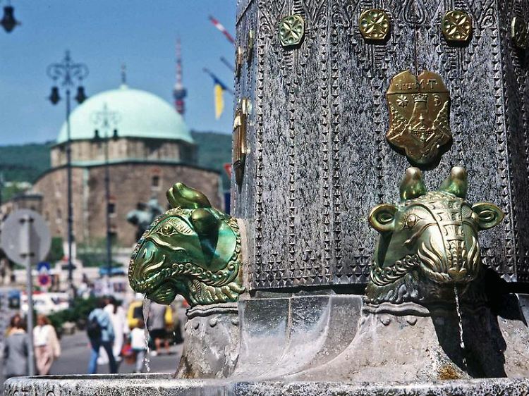Der Zsolnay-Brunnen auf dem Szechenyi-Platz in Pécs - hinten die zur Kirche umgebaute Pascha-Kasim-Gazi-Moschee.