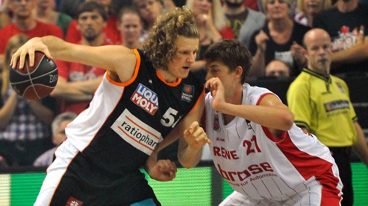Bambergs Tibor Pleiss (M.) und Ulms John Bryant im Zweikampf.