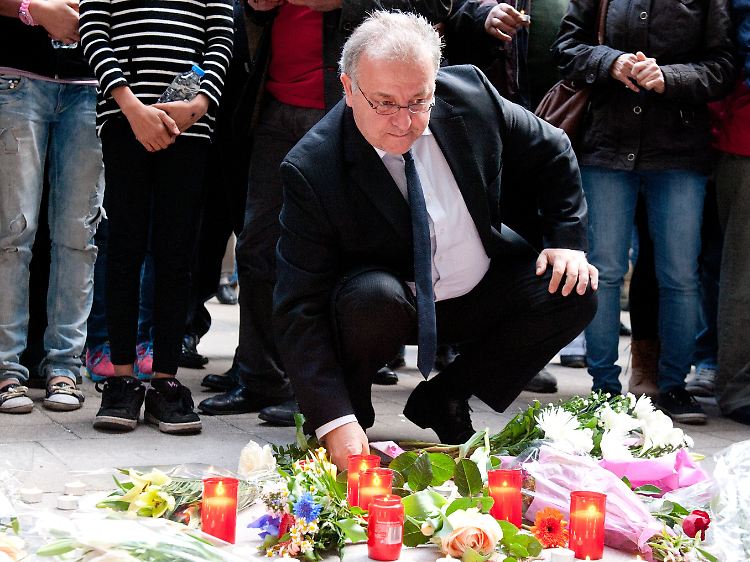 Der Vorstand der Türkischen Gemeinde in Deutschland, Kenan Kolat, entzündet am Hauseingang vor einer improvisierten Gedenkstätte eine Kerze.