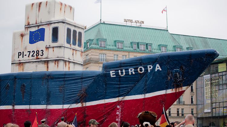 Greenpeace-Aktivisten protestieren mit einem nachgebauten Fischtrawler vor dem Brandenburger Tor in Berlin. Sie wollen mit dem 25 Meter langen Boot auf die Überfischung der Weltmeere aufmerksam machen.