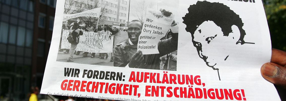 Demonstranten wenden sich 2006 in Dessau gegen die ihrer Meinung nach schleppende Aufklärung des Feuertodes von Oury Jalloh.
