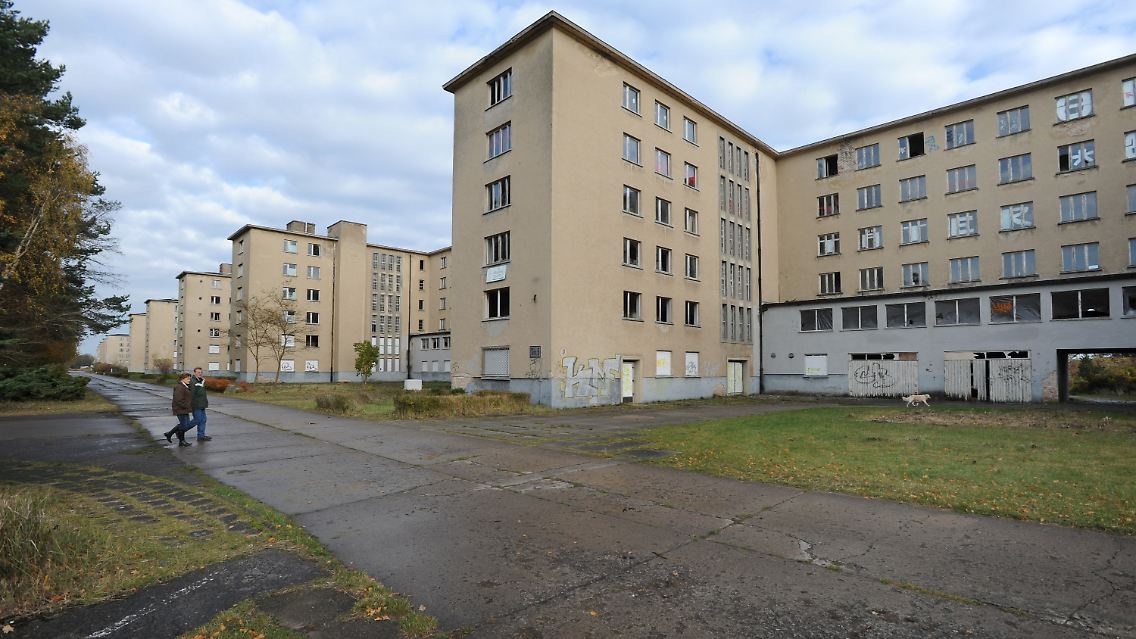 Touristen an einem Block der ehemaligen NS-Ferienanlage in Prora.