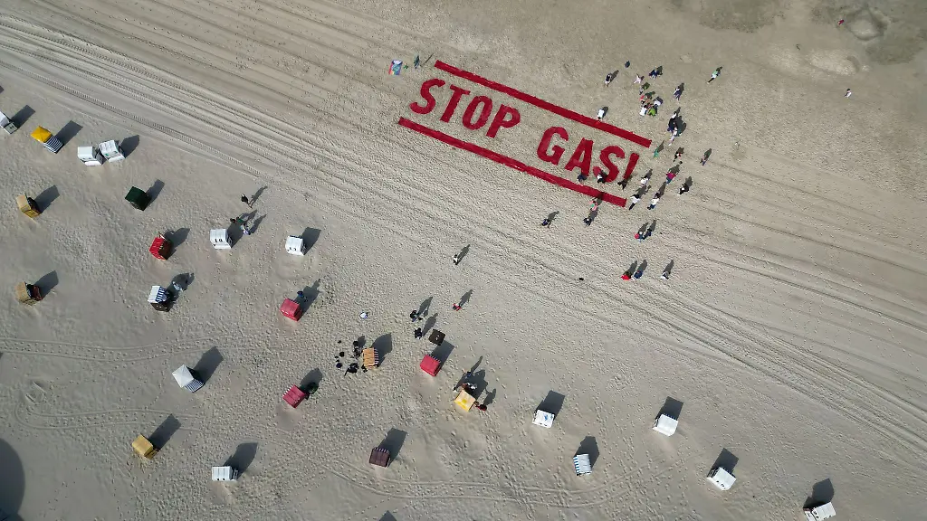 Klimaschutzaktivisten-von-Fridays-for-Future-schreiben-ihre-Forderung-nach-einem-Ende-der-Gasfoerderung-auf-den-Strand-der-Insel-Borkum