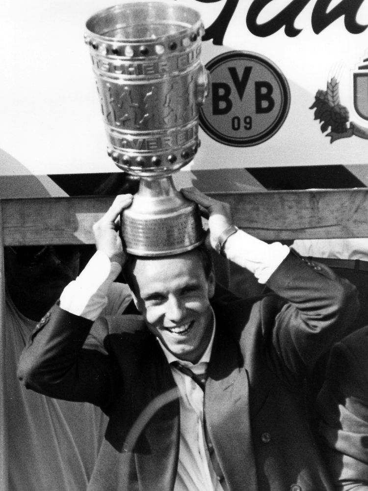 Stürmer Michael Rummenigge von Borussia Dortmund setzt sich den beim Triumphzug durch Dortmund den eroberten DFB-Pokal nach dem Sieg gegen Werder Bremen auf den Kopf (Archivfoto vom 25.06.1989).