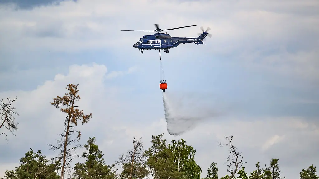 Brandenburgs-Innenminister-Rene-Wilke-parteilos-zieht-Hubschrauber-einem-Loeschflugzeug-bei-der-Brandbekaempfung-vor-Archivbild