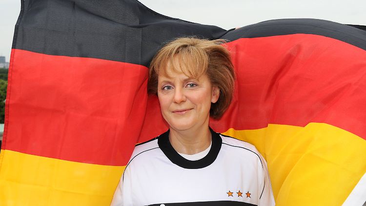 Nicht das Original, nur eine Kopie: Eine Merkel-Wachsfigur im Fußball-Outfit vor dem Brandenburger Tor in Berlin.