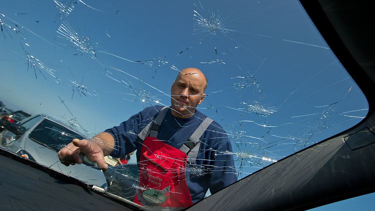 Kfz-Meister Ingo Peters aus Gingst untersucht auf dem Hiddensee-Parkplatz am Hafen von Schaprode die durch einen Hagelschauer zerstörte Frontscheibe eines Autos.