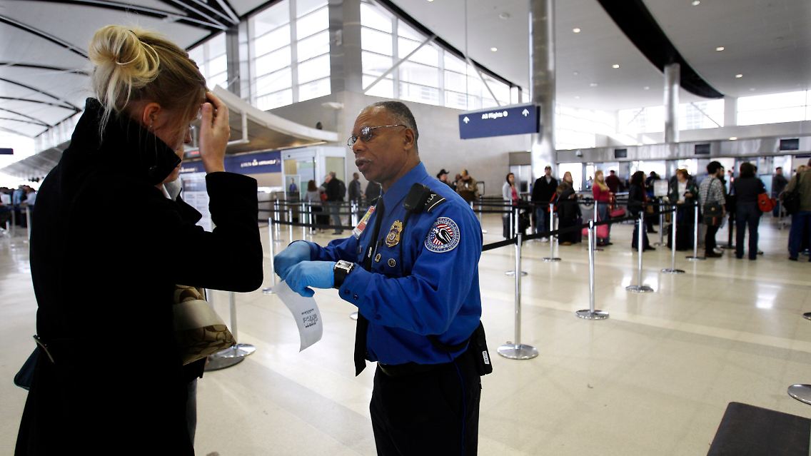 Ein Sicherheitsbeamter hilft einer Reisenden auf dem Flughafen von Detroit.