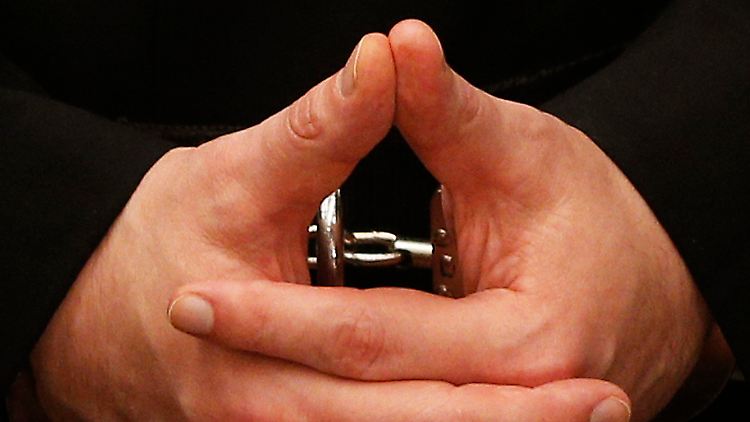 Die gefesselten Hände des Massenmörders.