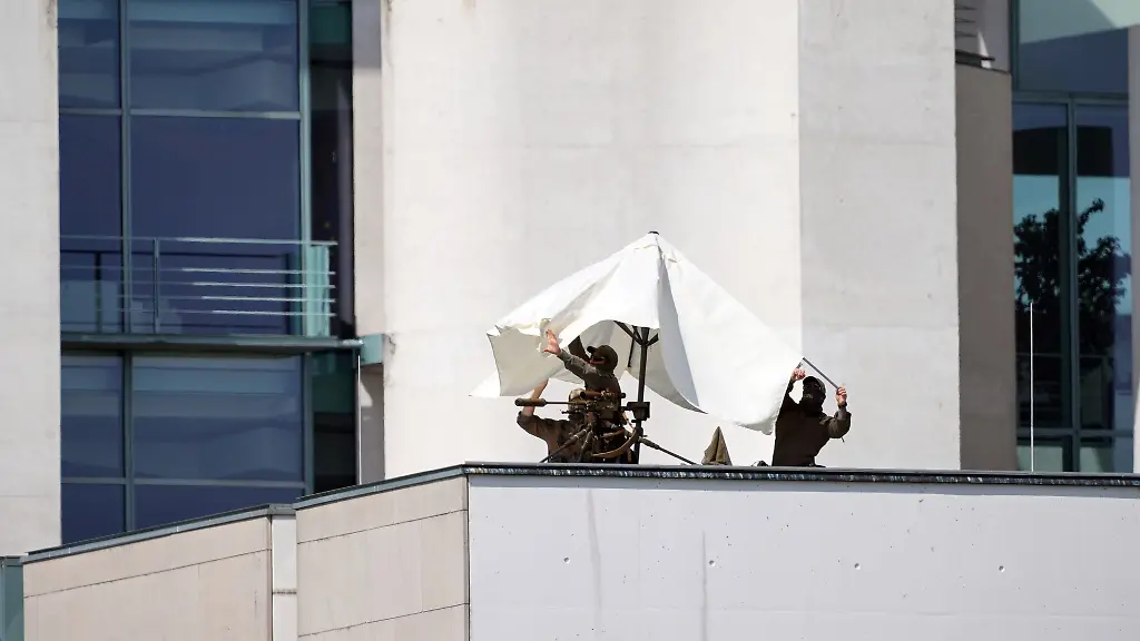 Scharfschuetzen-spannen-einen-Sonnenschirm-auf-einem-Vordach-des-Kanzleramts-auf