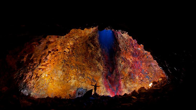 Die Magmakammer des Vulkans ist 120 Meter hoch. Scheinwerfer strahlen die in vielen Farben schillernden Wände an.
