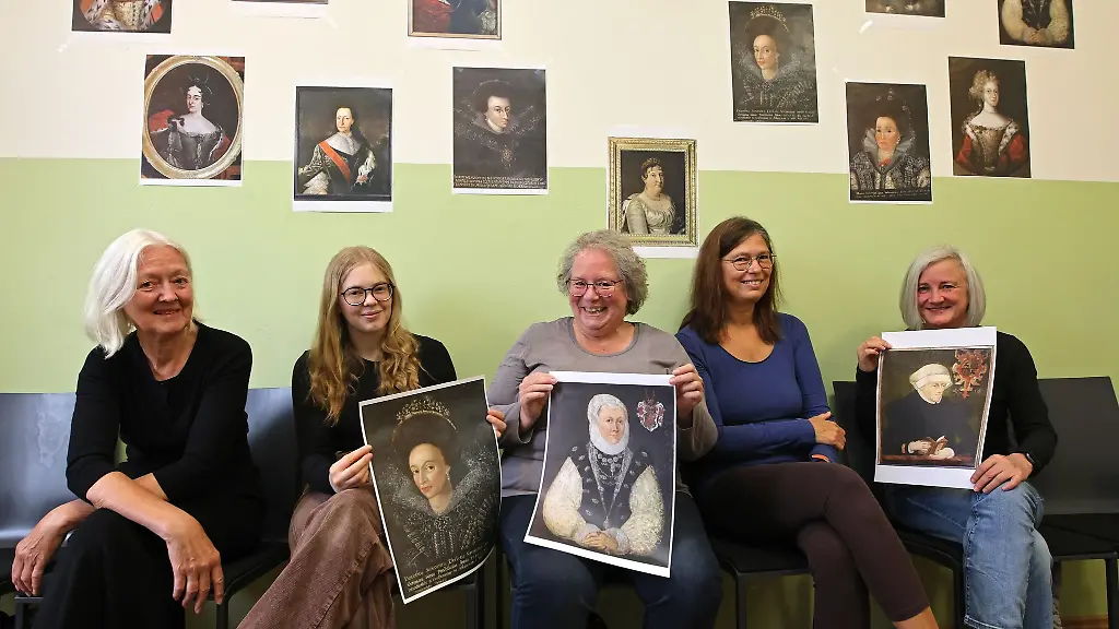 Teilnehmerinnen-sitzen-vor-einem-Fototermin-mit-historischen-Portraets-von-ehemaligen-Aebtissinnen-im-Stadtarchiv-der-Stadt-Quedlinburg