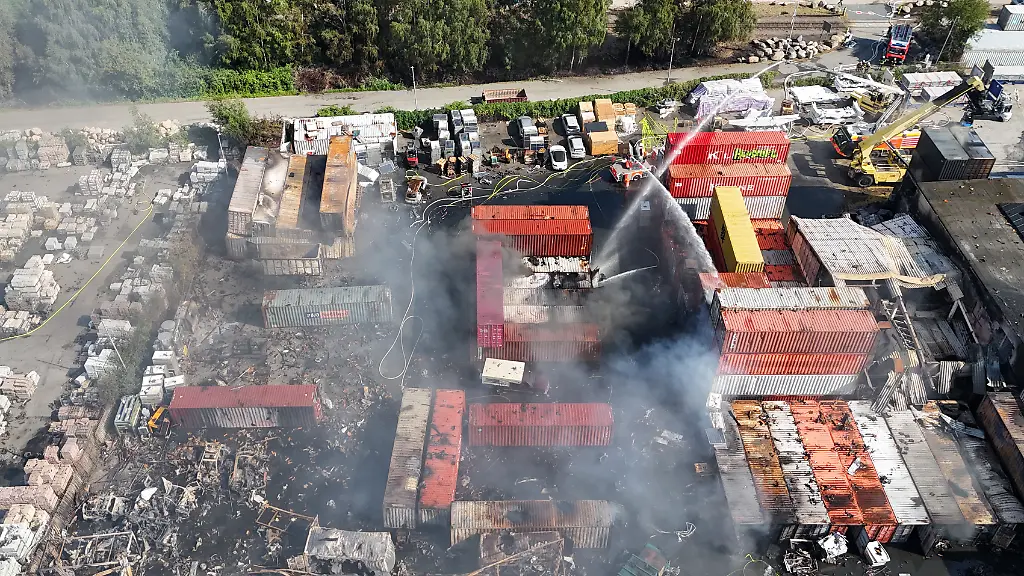 Einsatzkraefte-der-Feuerwehr-loeschen-den-Brand-in-einem-Industriegebiet-im-Hamburger-Hafen