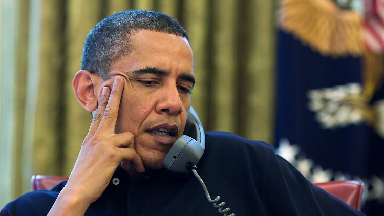 Obama telefoniert an seinem Schreibtisch im Weißen Haus.