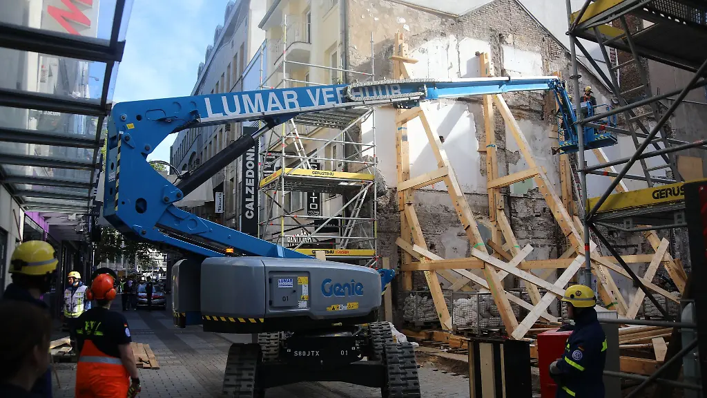 Einsatzkraefte-stuetzen-eine-einsturzgefaehrdete-Gebaeudewand-an-einer-Baustelle