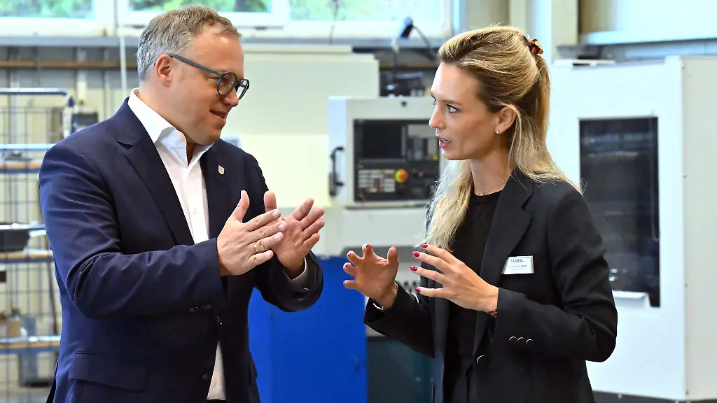 Mario-Voigt-l-CDU-Ministerpraesident-von-Thueringen-spricht-mit-Karlotta-Gruendobler-Geschaeftsfuehrerin-der-Eliog-Industrieofenbau-GmbH-Voigt-sieht-ueberbordende-Buerokratie-als-zunehmende-Belastung-fuer-Thueringer-Unternehmen