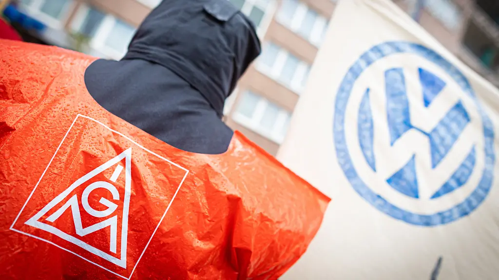 Ein-VW-Beschaeftigter-nimmt-an-einer-Kundgebung-der-IG-Metall-vor-dem-Hotel-welches-fuer-die-fuenfte-Tarifrunde-dient-teil-Im-Ringen-um-Einsparungen-bei-VW-treffen-Vertreter-von-Volkswagen-und-IG-Metall-zu-ihrer-fuenften-Tarifrunde-zusammen